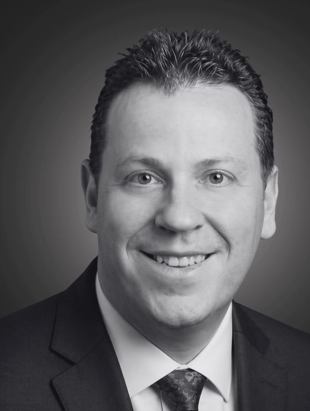 Dr Mark Powell — studio headshot, black and white